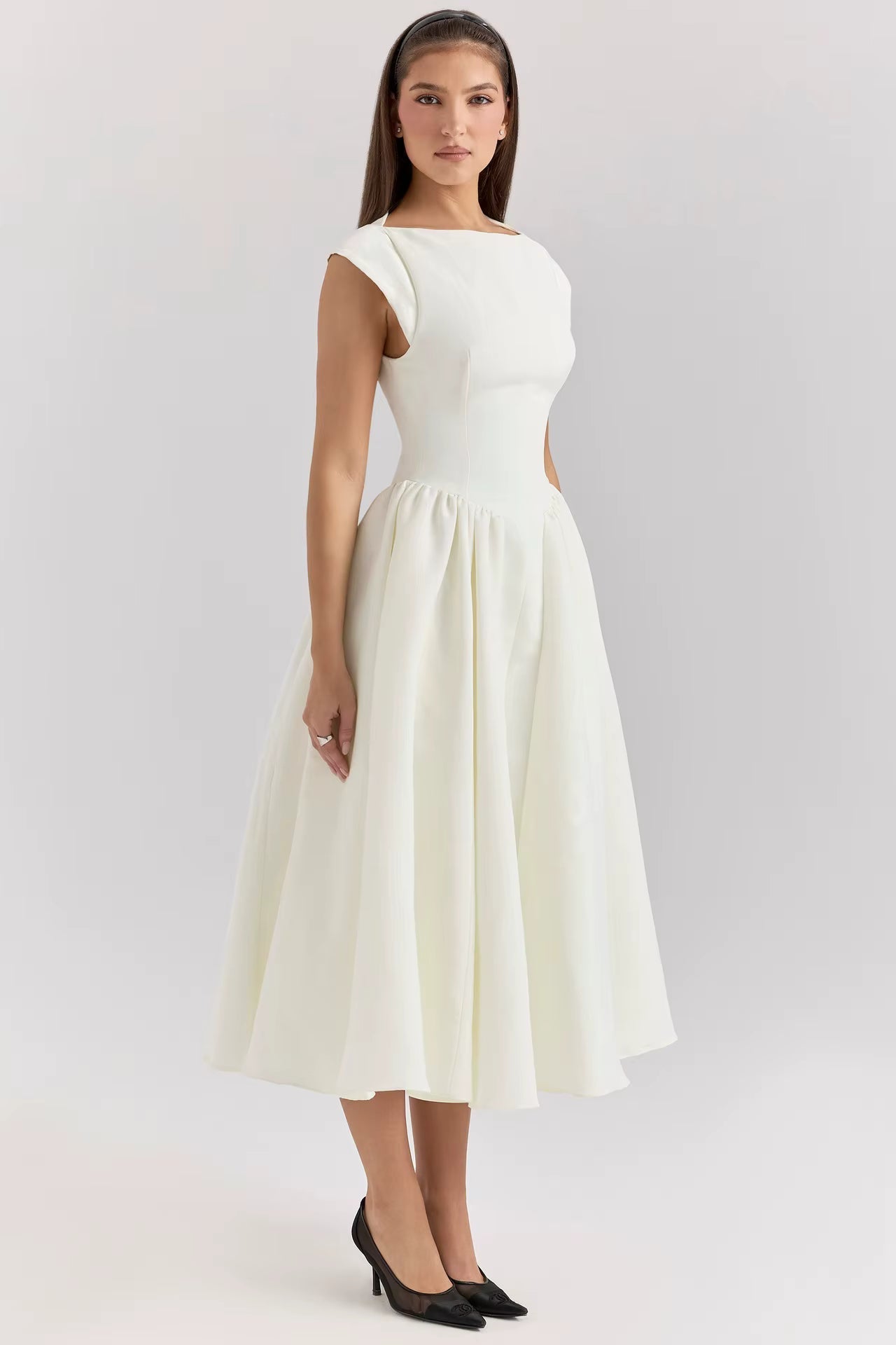 Woman wearing a white dress on a light gray background
