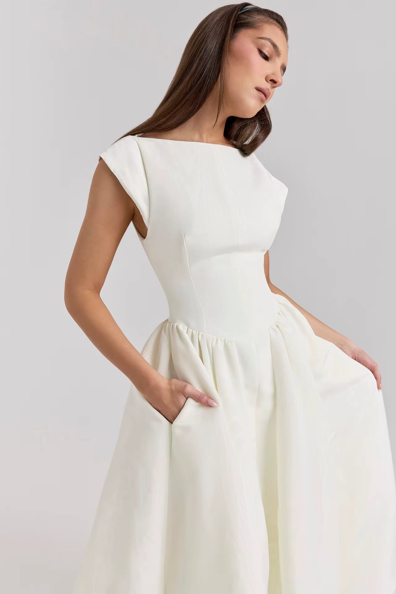 Woman wearing a white dress against a plain background