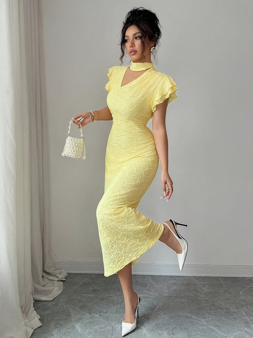 A woman models a pale yellow textured midi dress with ruffled short sleeves, a high keyhole neckline, and a fitted silhouette. She is holding a small white woven handbag and wearing white pointed-toe heels, standing in a room with a gray floor and light gray wall.