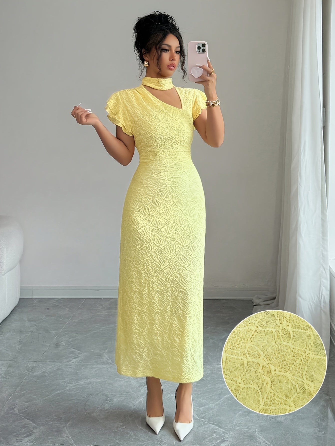 A woman takes a mirror selfie wearing a pale yellow textured midi dress with a high mock neck and short puff sleeves. The image includes a circular inset in the bottom right corner showing a close-up of the dress's textured fabric.