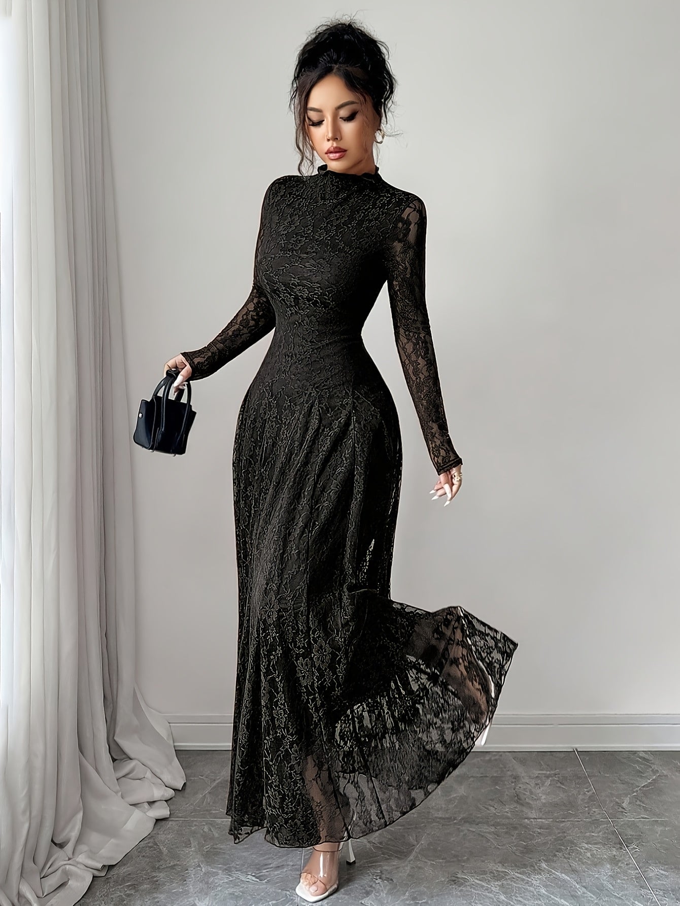 Woman wearing a long brown lace dress in a room with gray walls and a gray carpet.