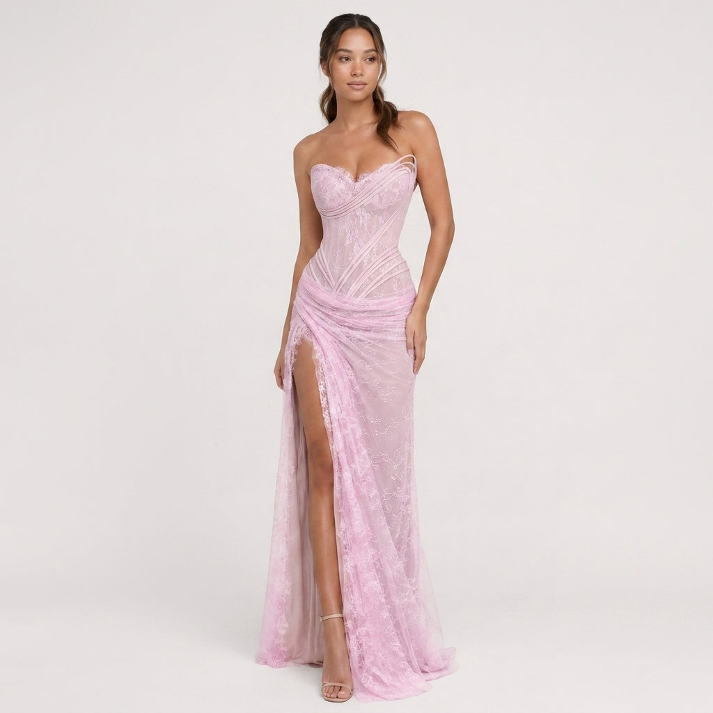 Woman wearing a pink strapless gown with a high slit on a white background
