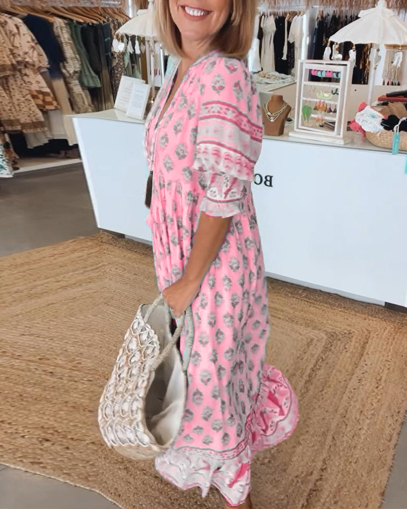 Woman in a pink dress with floral patterns standing in a store.