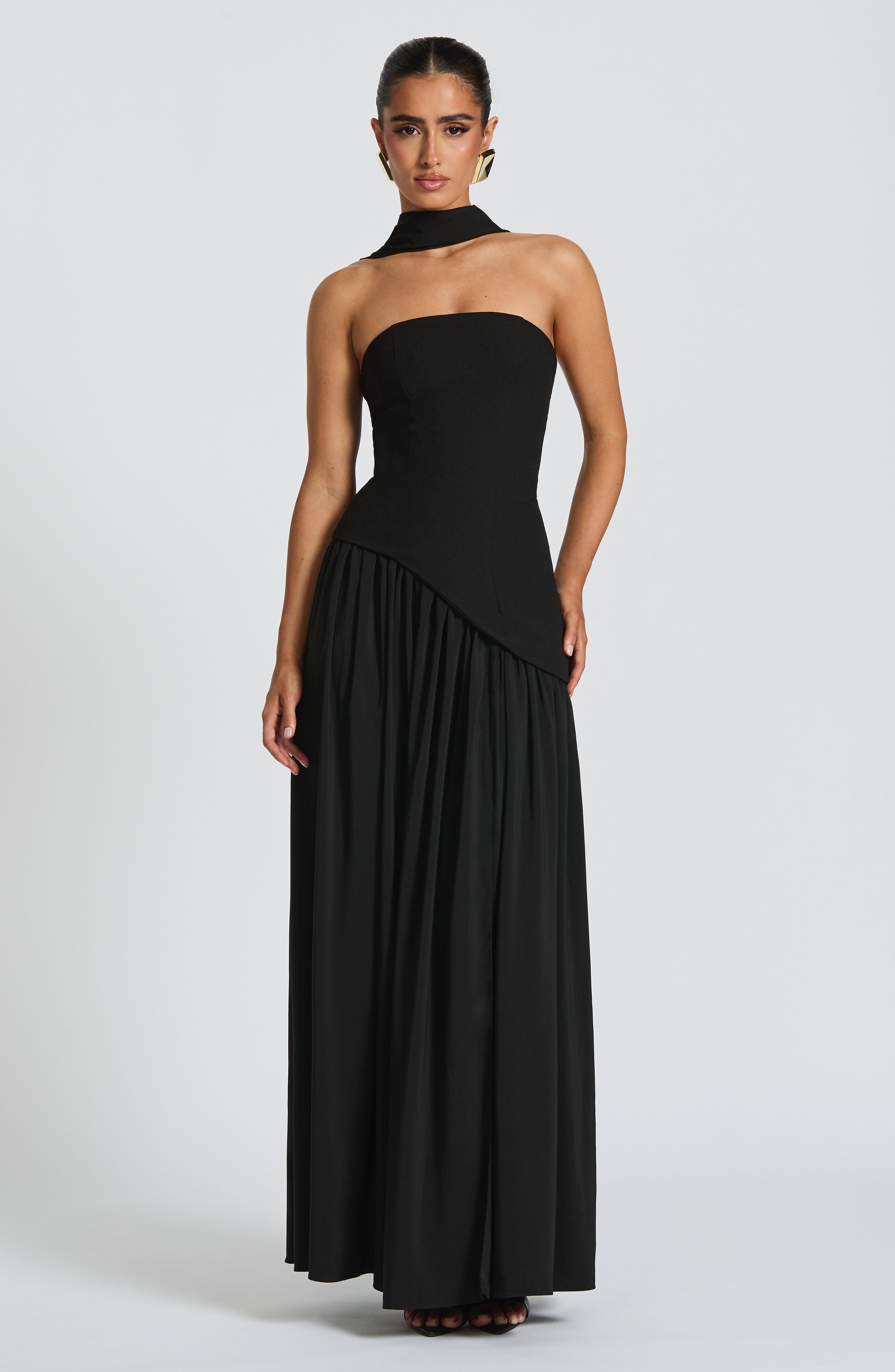 Woman wearing a black strapless gown on a white background