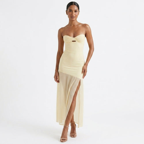 Woman wearing a strapless, light-colored evening gown on a white background