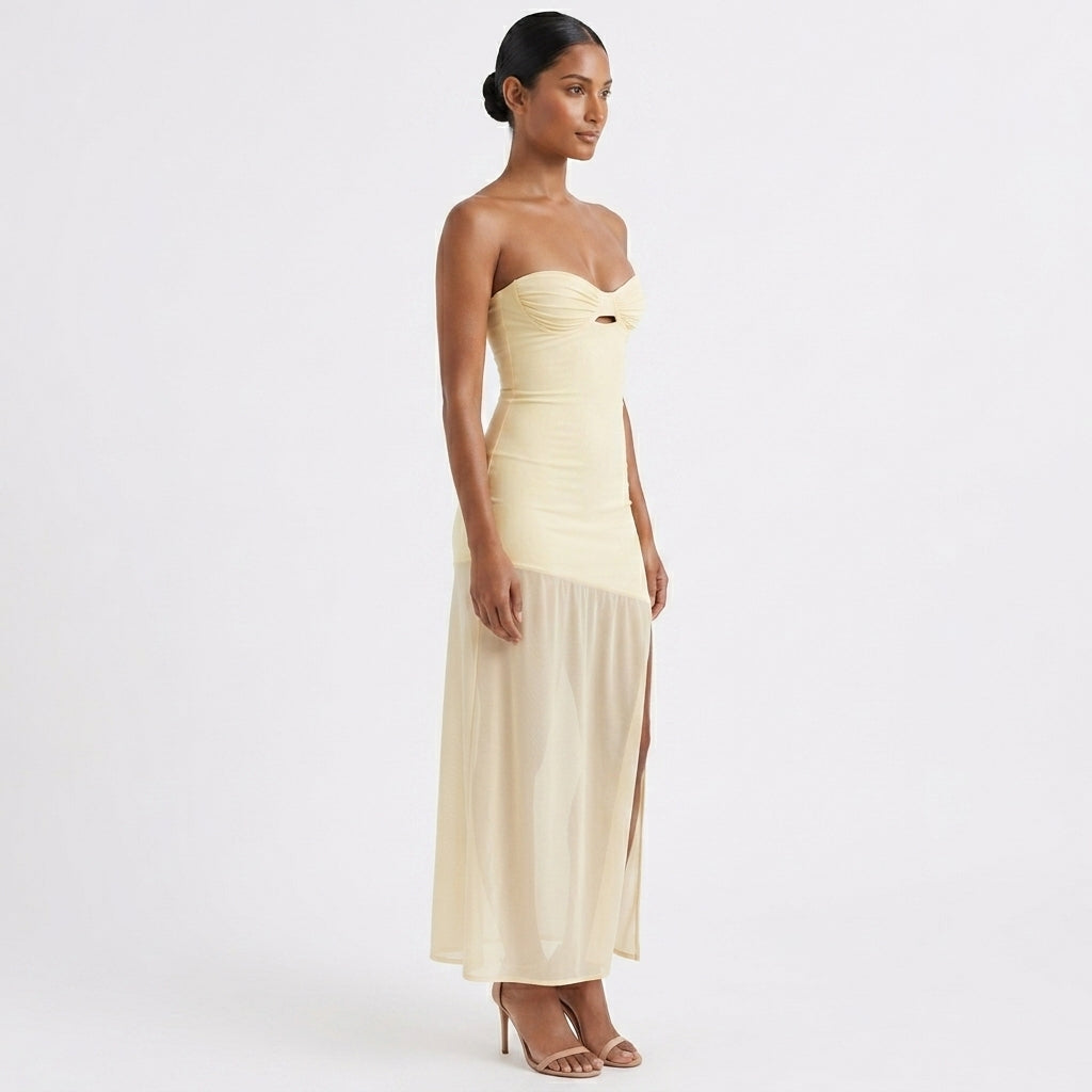 Woman wearing a strapless, light-colored evening gown on a white background