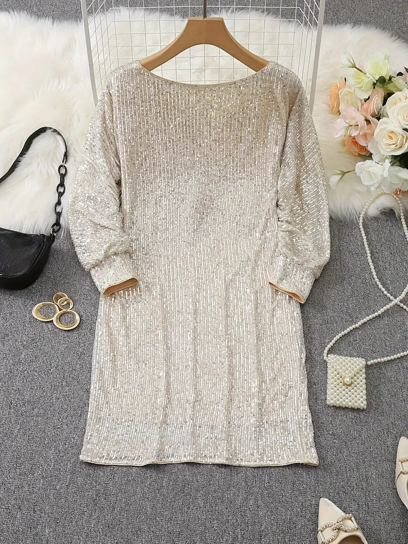 Gold glitter dress on a hanger with accessories on a gray surface