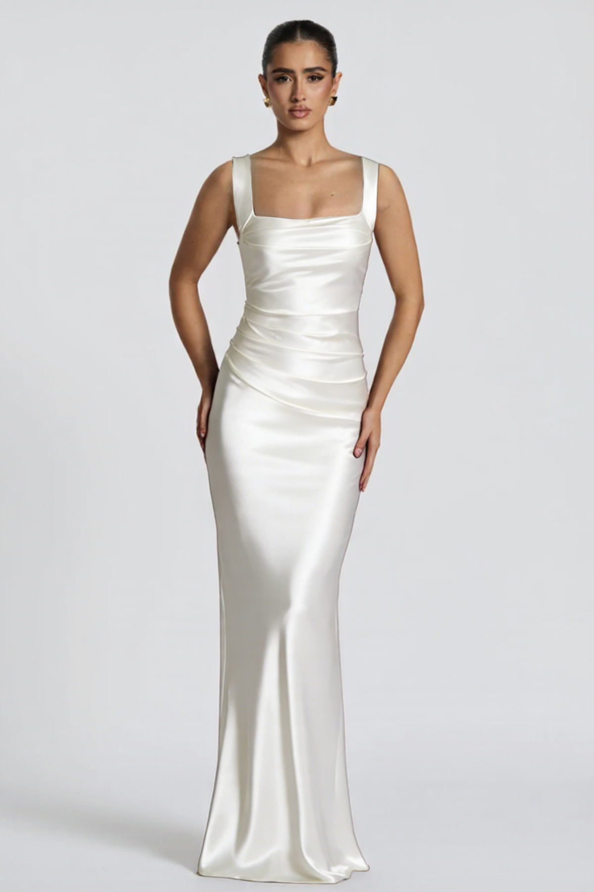 Woman wearing a white evening gown against a plain background
