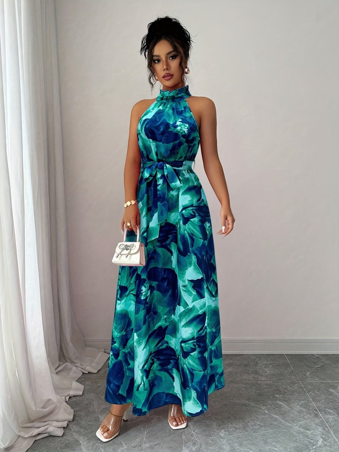 Woman wearing a blue floral dress standing against a neutral background